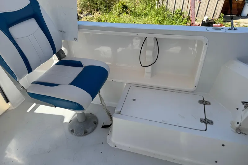 Slide: The Image of 1988 Chris-Craft 215 Sea Hawk interior with blue and white seating and storage compartment. - 44