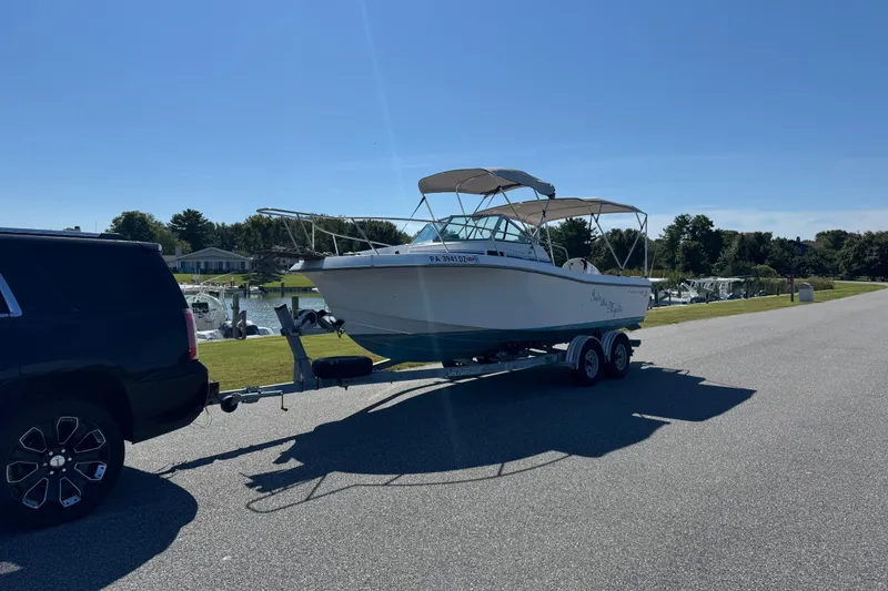 Slide: The Image of 1988 Chris-Craft 215 Sea Hawk boat on trailer, parked on sunny road. - 8