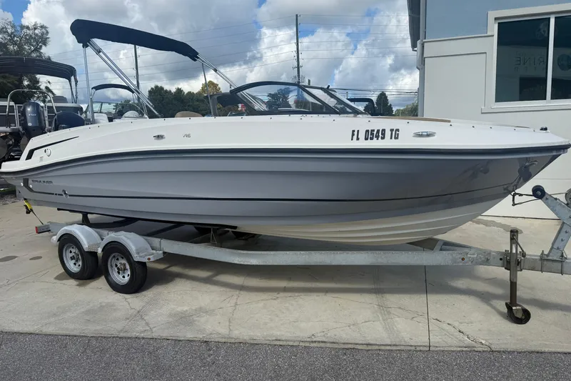 The Image of 2022 Bayliner VR6 Bowrider OB on trailer, parked outdoors under cloudy sky. - 1