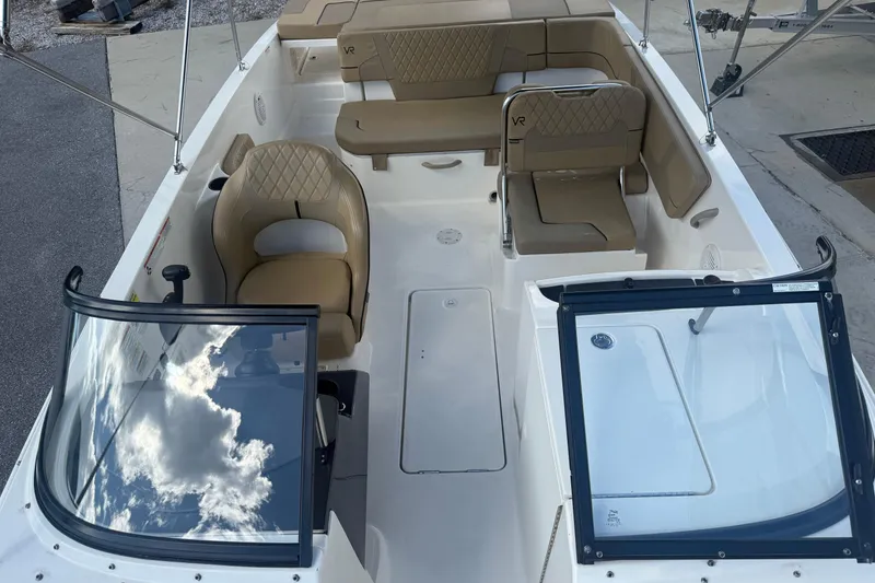 Slide: The Image of 2022 Bayliner VR6 Bowrider OB interior with tan seating and open windshield. - 3