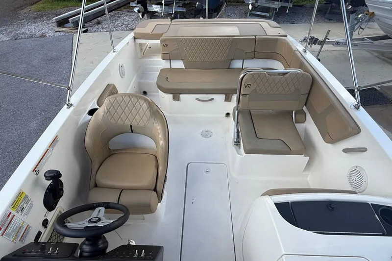 Slide: The Image of 2022 Bayliner VR6 Bowrider OB interior with beige seating and steering console. - 6
