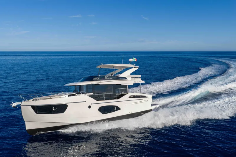 The Image of Luxurious 2027 Absolute 50 Navetta yacht cruising on open sea under clear blue sky. - 1