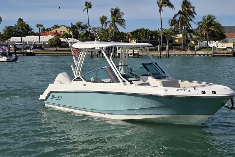 Slide: The Image of 2021 Boston Whaler 240 Vantage boat cruising on a sunny day with palm trees in the background. - 10