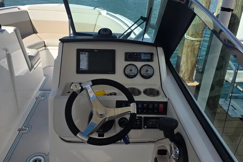 Slide: The Image of 2021 Boston Whaler 240 Vantage helm with steering wheel and navigation controls. - 17