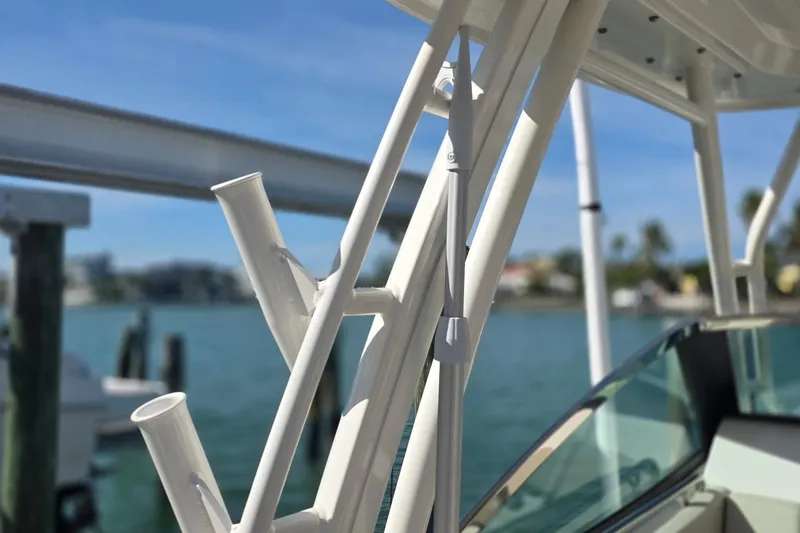 Slide: The Image of 2021 Boston Whaler 240 Vantage boat detail with rod holders, docked by the water. - 32