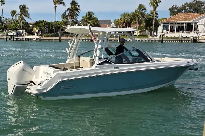 Slide: The Image of 2021 Boston Whaler 240 Vantage boat cruising on a sunny day with palm trees in the background. - 4