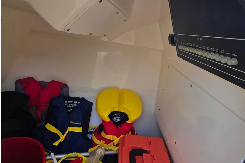 Slide: The Image of Storage area of 2021 Boston Whaler 240 Vantage with life jackets and control panel. - 40