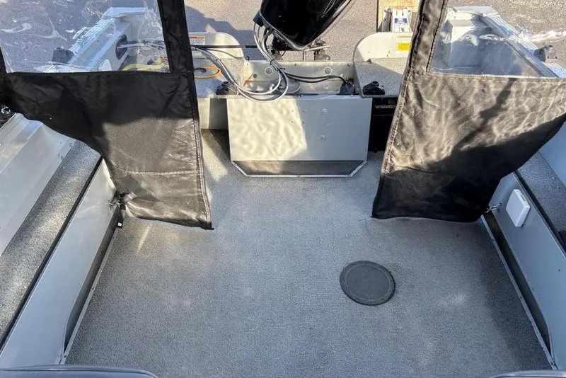 Slide: The Image of 2016 Smoker Craft Pro Tracer 162 boat interior with carpeted floor and protective covers. - 2