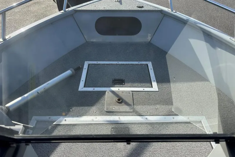 Slide: The Image of 2016 Smoker Craft Pro Tracer 162 boat interior with carpeted deck and railing. - 7