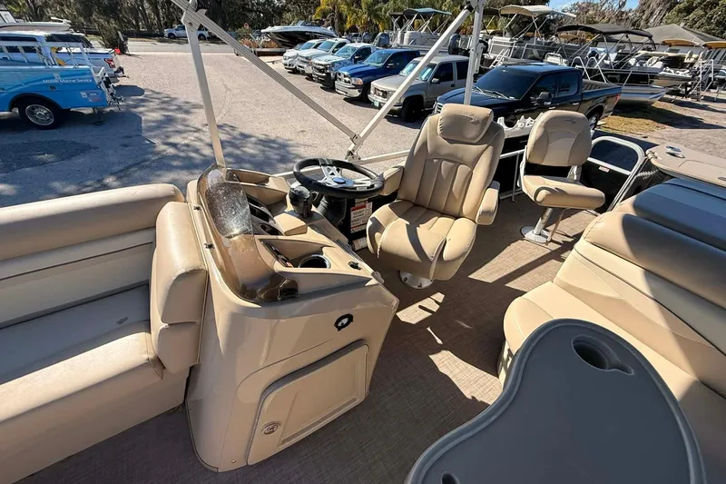 Slide: The Image of 2015 Bennington 20 SF pontoon boat interior with beige seating and steering console. - 6