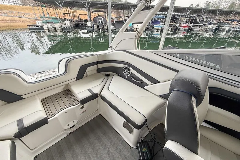 Slide: The Image of 2019 Yamaha Boats 242 Limited S E-Series interior with sleek seating and marina view. - 13