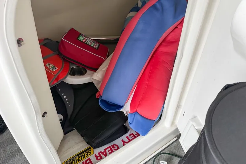 Slide: The Image of Storage compartment in 2019 Yamaha Boats 242 Limited S E-Series with life jackets and safety gear. - 26