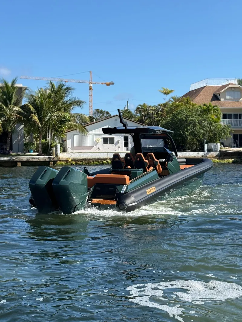 Slide: The Image of 2025 Skipper-BSK 38 boat cruising on a sunny day near waterfront homes. - 17
