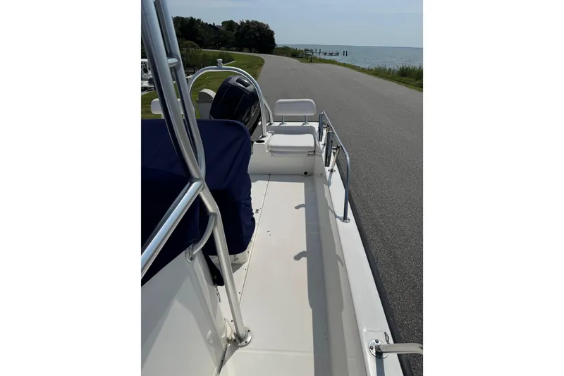 Slide: The Image of 2013 Boston Whaler 210 Montauk boat on a lakeside road, showcasing interior seating. - 10