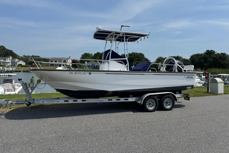 Slide: The Image of 2013 Boston Whaler 210 Montauk boat on trailer, parked near waterfront homes. - 2