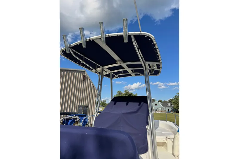 Slide: The Image of 2013 Boston Whaler 210 Montauk boat with blue canopy under clear sky. - 26