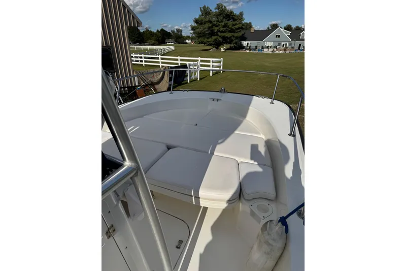 Slide: The Image of 2013 Boston Whaler 210 Montauk boat with cushioned seating, docked near a house. - 28