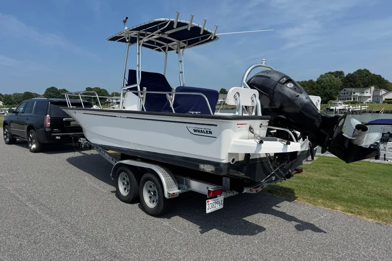 Slide: The Image of 2013 Boston Whaler 210 Montauk boat on trailer, parked near waterfront homes. - 3