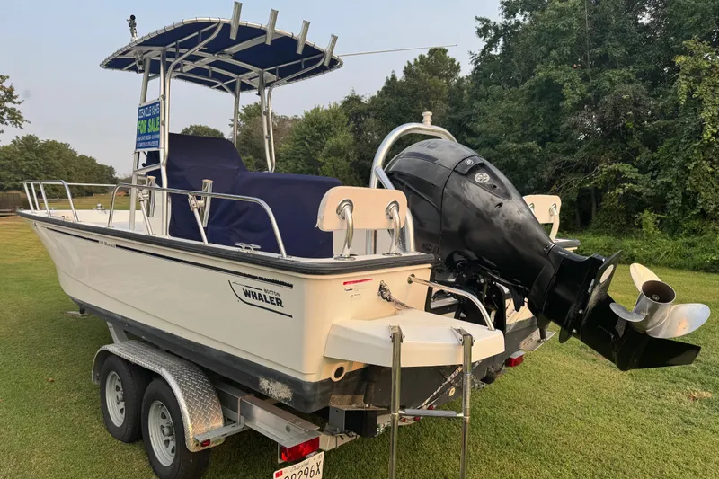 Slide: The Image of 2013 Boston Whaler 210 Montauk boat on trailer, displayed outdoors. - 33