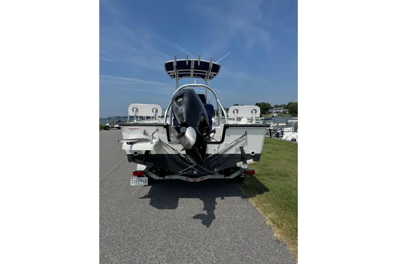 Slide: The Image of 2013 Boston Whaler 210 Montauk boat, rear view with outboard motor, parked on a road. - 4