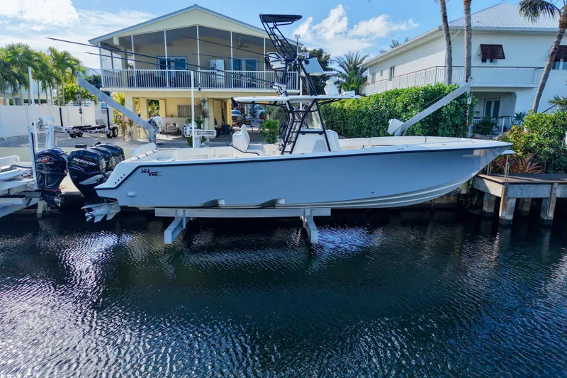 The Image of 2019 SeaVee 370Z boat docked by waterfront homes, featuring dual Mercury engines. - 1