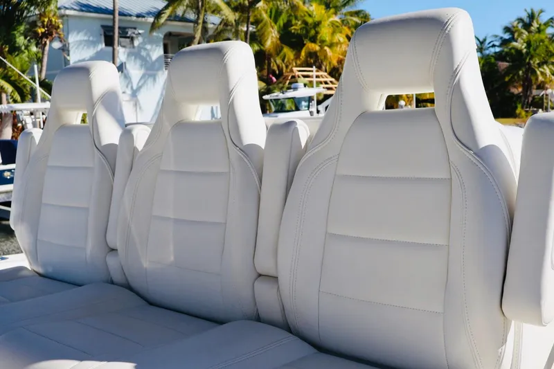 Slide: The Image of White leather seats on a 2019 SeaVee 370Z boat, surrounded by tropical scenery. - 10
