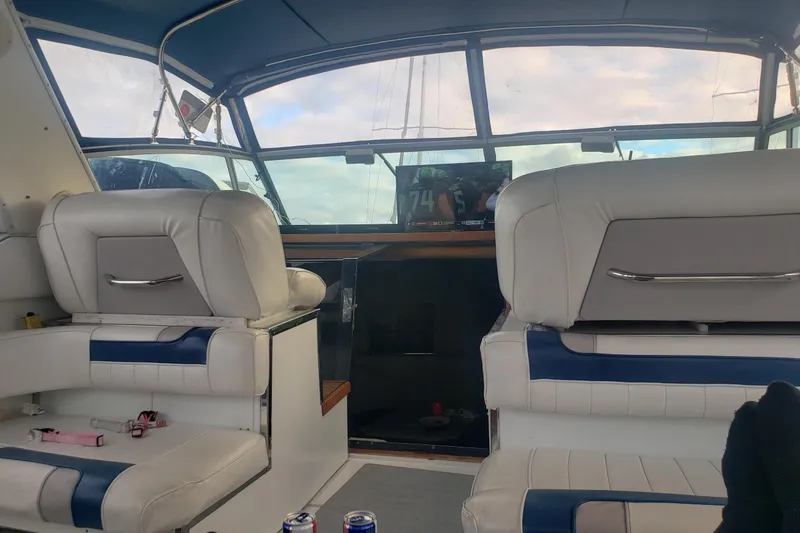 Slide: The Image of Interior of a 1988 Sea Ray 390 Express Cruiser with white seating and a view of the cockpit. - 14