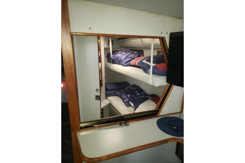 Slide: The Image of Interior of 1988 Sea Ray 390 Express Cruiser with bunk beds and mirror reflection. - 2