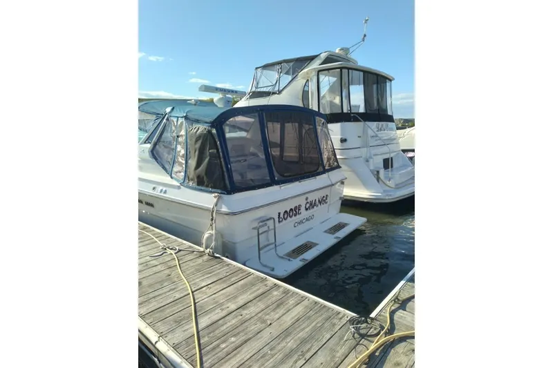 Slide: The Image of 1988 Sea Ray 390 Express Cruiser docked, featuring blue canvas cover and "Loose Change" name. - 33