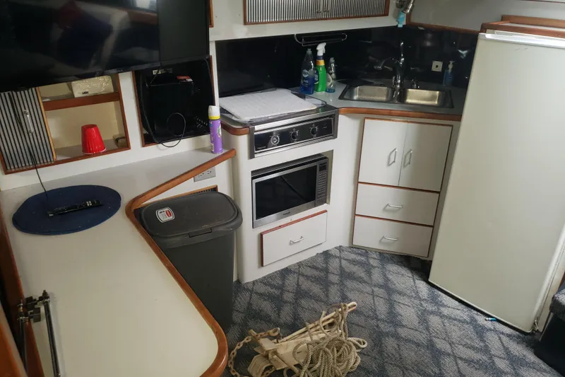 Slide: The Image of 1988 Sea Ray 390 Express Cruiser interior kitchen with appliances and storage. - 4
