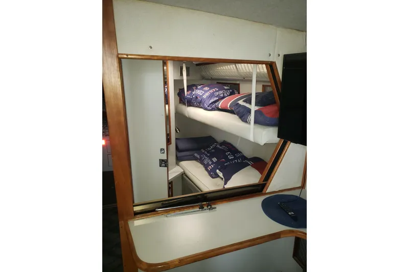 Slide: The Image of 1988 Sea Ray 390 Express Cruiser cabin with bunk beds and mirror reflection. - 8