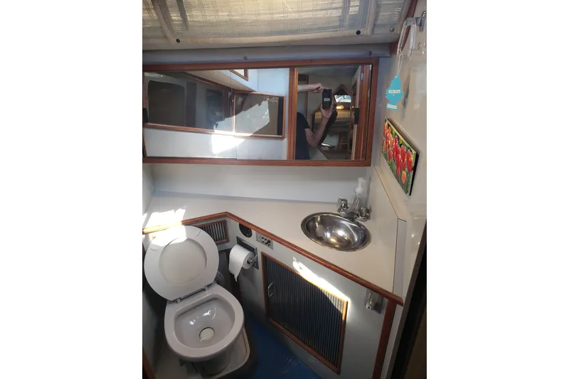 Slide: The Image of 1988 Sea Ray 390 Express Cruiser bathroom with toilet, sink, and mirror. - 9