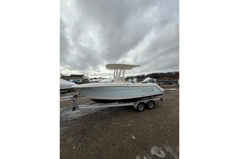The Image of 2021 Robalo R222 Center Console boat on trailer under cloudy sky. - 1