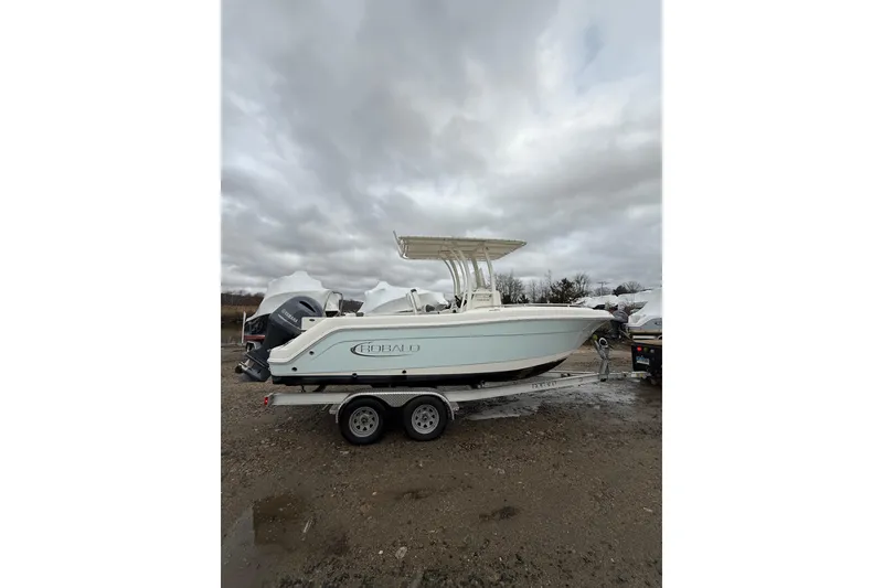 Slide: The Image of 2021 Robalo R222 Center Console boat on trailer under cloudy sky. - 2
