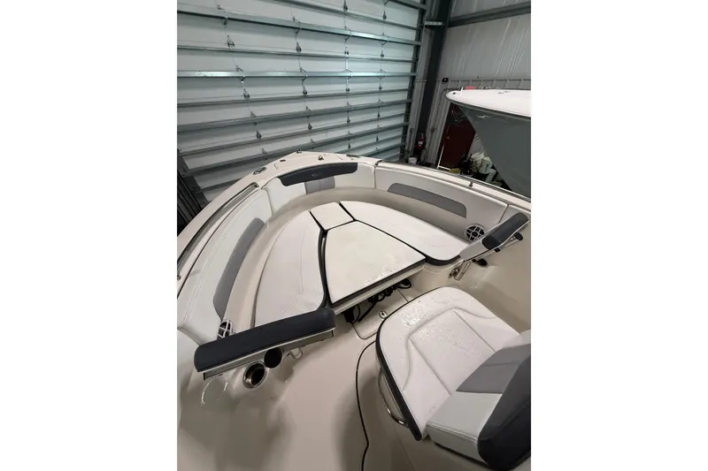 Slide: The Image of 2021 Robalo R222 Center Console boat interior with cushioned seating in storage. - 22