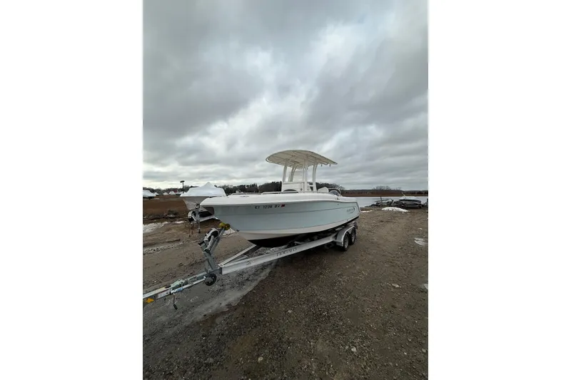 Slide: The Image of 2021 Robalo R222 Center Console boat on trailer under cloudy sky. - 4