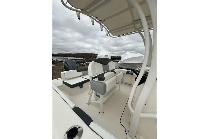 Slide: The Image of 2021 Robalo R222 Center Console boat interior with seating and console, under cloudy sky. - 8