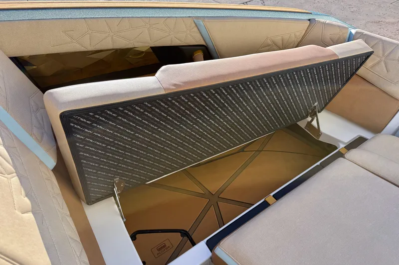 Slide: The Image of 2026 Nautique Super Air Nautique G25 Paragon interior seating with storage compartment open. - 13