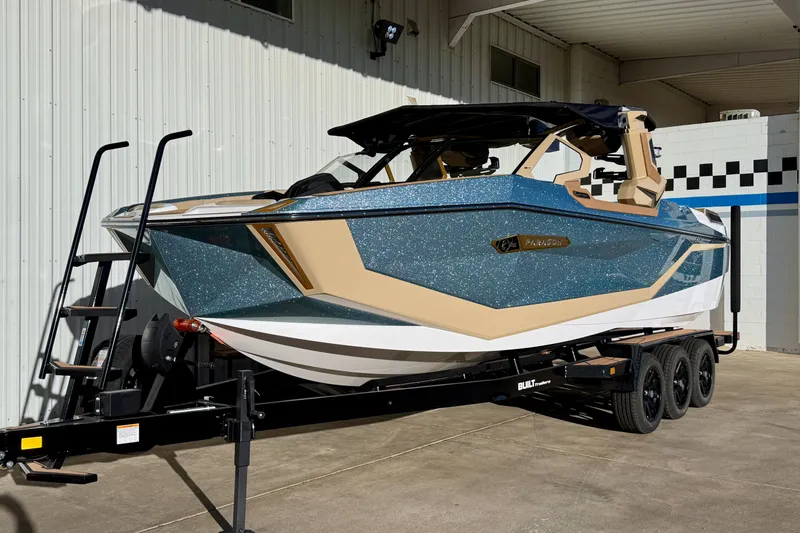 Slide: The Image of 2026 Nautique Super Air Nautique G25 Paragon boat on trailer, parked outdoors. - 2