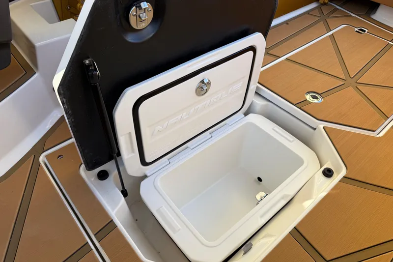 Slide: The Image of 2026 Nautique Super Air Nautique G25 Paragon storage compartment with open lid on deck. - 27
