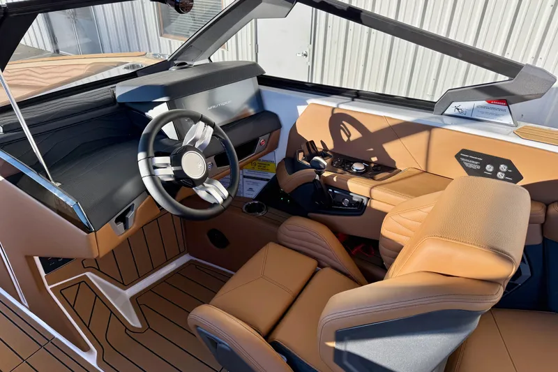 Slide: The Image of 2026 Nautique Super Air Nautique G25 interior with luxurious tan leather seating and modern dashboard. - 13