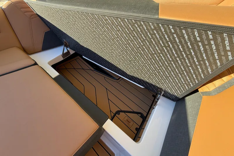 Slide: The Image of 2026 Nautique Super Air Nautique G25 interior storage compartment with cushioned seating. - 17