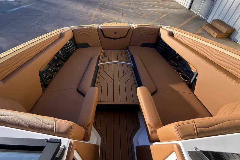 Slide: The Image of 2026 Nautique Super Air Nautique G25 interior with tan seating and cup holders. - 20