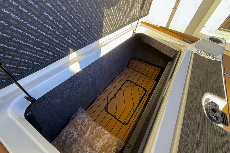 Slide: The Image of 2026 Nautique Super Air Nautique G25 storage compartment with branded interior and sleek design. - 25