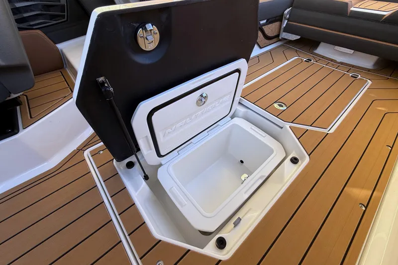 Slide: The Image of 2026 Nautique Super Air Nautique G25 boat with open storage compartment on teak deck. - 29