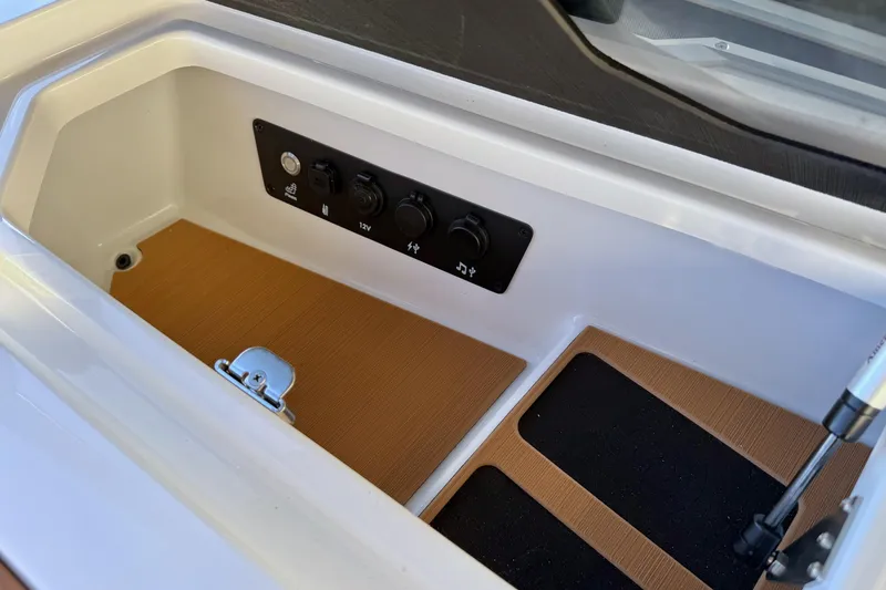 Slide: The Image of 2026 Nautique Super Air Nautique G25 storage compartment with control panel and latch. - 30