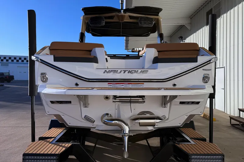 Slide: The Image of 2026 Nautique Super Air Nautique G25 boat, rear view, docked outdoors. - 5