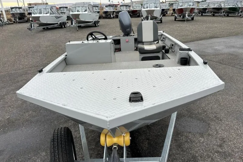 Slide: The Image of 2023 Smoker Craft Sportsman 1660 boat on trailer, displayed in a lot with other boats. - 2