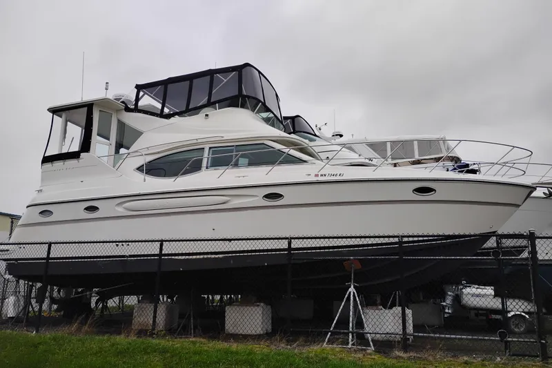 The Image of 2001 Maxum 4100 SCA yacht on dry dock, overcast sky background. - 0