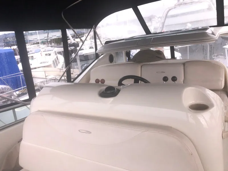 Slide: The Image of 2001 Maxum 4100 SCA yacht interior with steering wheel and dashboard, docked at marina. - 12